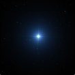 “Bright blue-white star Sirius shining in the dark night sky, surrounded by smaller stars.”